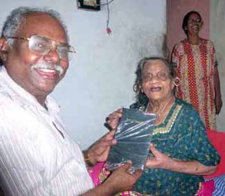 Eliyamma receives Bible from Paul Ciniraj
