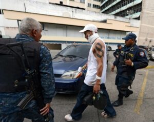 A wounded gang member is apprehended by police officers in Tegucigalpa, Honduras. Over 4,700 gang members are youth or children. 