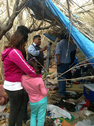 Gonzolo (center) ministers at homeless camp in riverbed