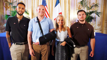 Anthony Sadler, left, Alek Skarlatos, right, and Spencer Stone, second from left, pose with Jane D. Hartley, U.S. Ambassador to France. 