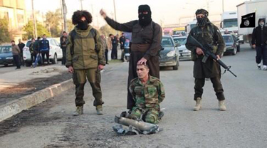 ISIS fighter prepares to behead a captured Peshmerga fighter in Mosul