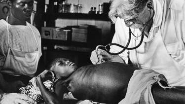 Albert Schweitzer treats patient at his hospital in Lambarene