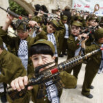 Palestinian boys dressed in uniforms of Palestianian security forces take part in Nakba rally in West Bank city of Nablus